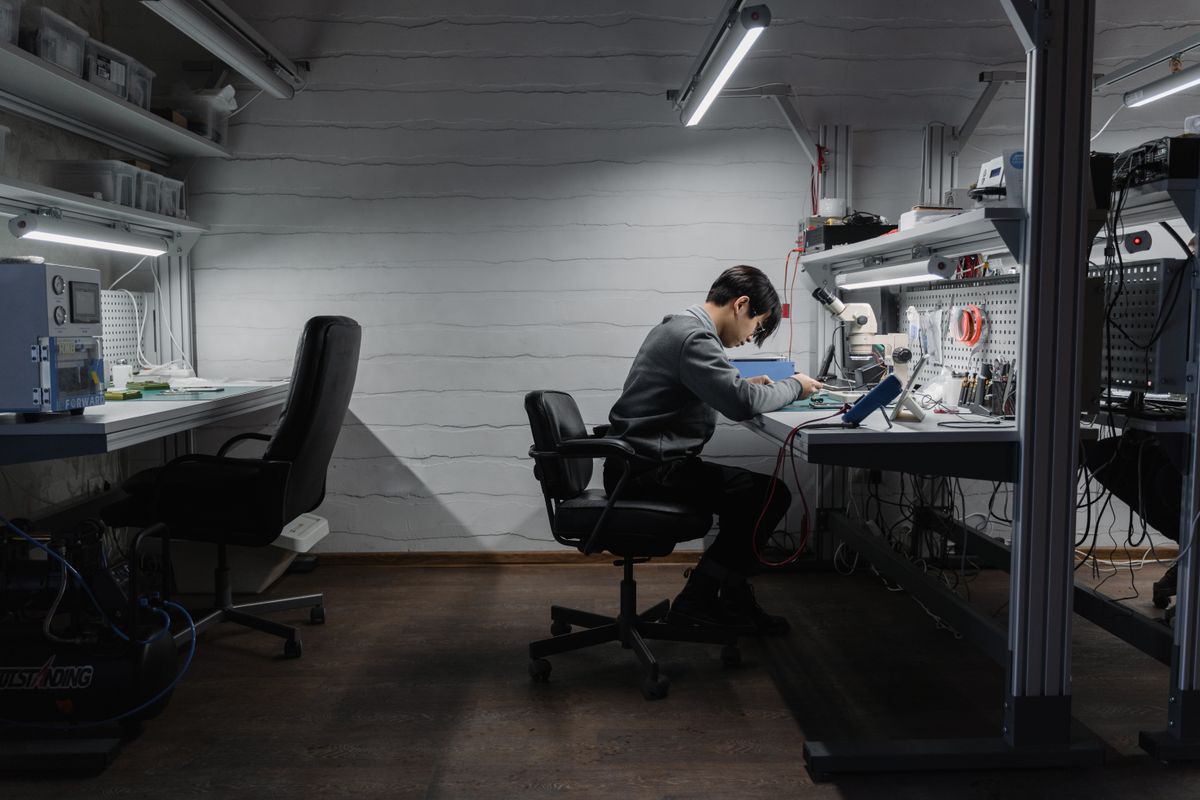 An engineer working at a bench in a technical workspace